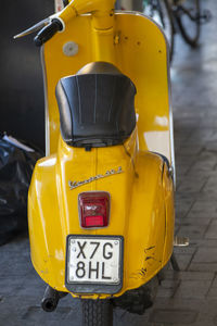 Close-up of yellow car on road