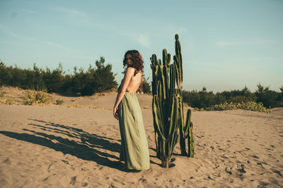 Woman standing on beach against sky