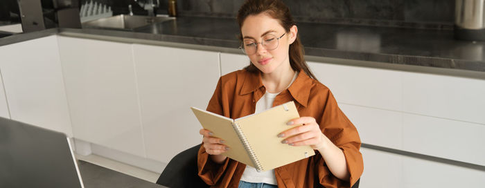 Portrait of young woman holding book