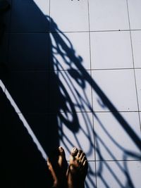 Low section of person standing on tiled floor