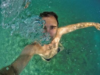 High angle view of shirtless man swimming in sea