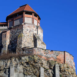Low angle view of old castle against clear blue sky