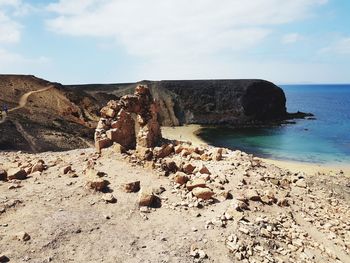 Rocks on beach against sky