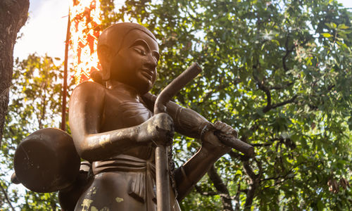 Low angle view of statue against trees