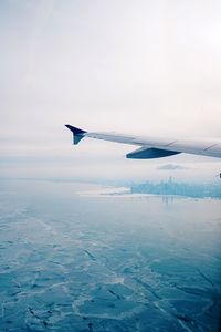 Airplane flying over sea against sky