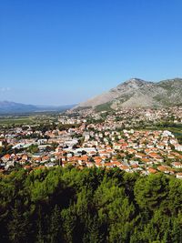 Aerial view of townscape against clear blue sky