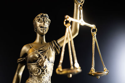 Detail of lady justice statue isolated on dark background