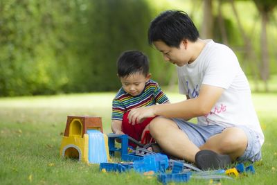 Rear view of boy sitting at toy car