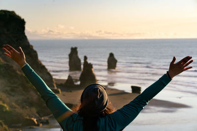 Rear view of woman photographing sea against sky