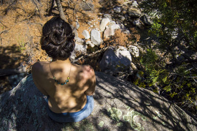 High angle of woman sitting on rock