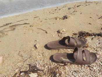 High angle view of shoes on sand at beach