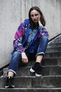 Portrait of young woman sitting on steps