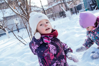 Children playing with snow outdoors. winter holidays in the countryside