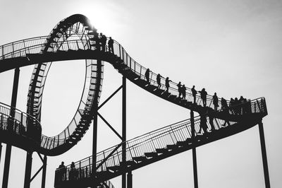 Low angle view of people at tiger and turtle magic mountain against clear sky