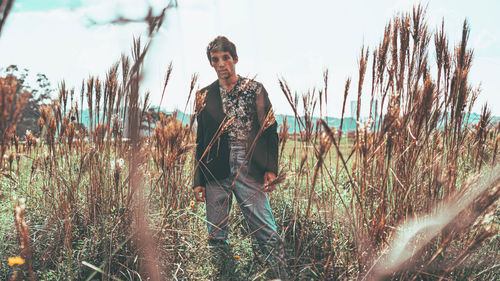 Portrait of young man standing on field