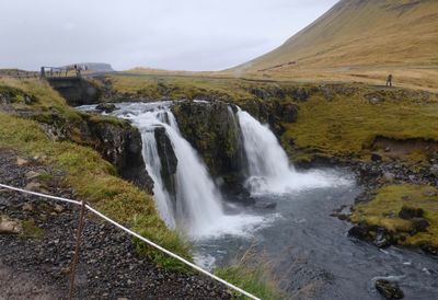 Scenic view of waterfall against sky