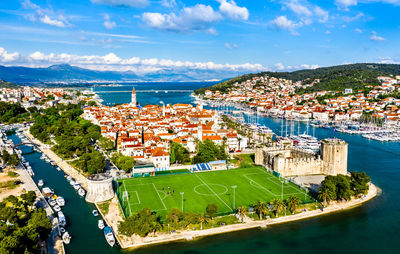 High angle view of city by sea against sky