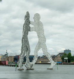 Sculpture of building against cloudy sky