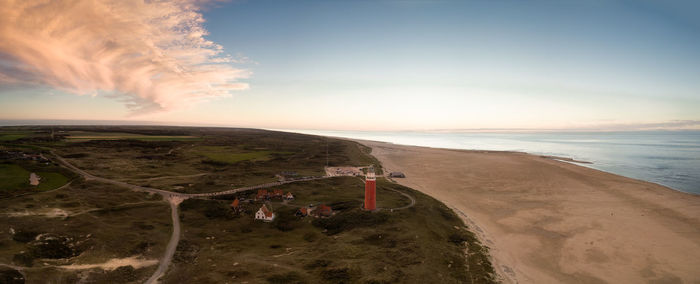 Scenic view of landscape and sea against sky during sunset