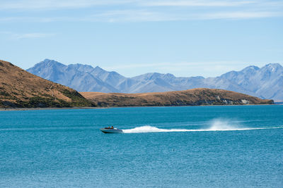 People boating in summer on lake tekapo, new zealand