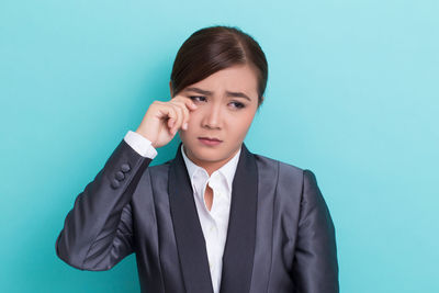 Portrait of mid adult woman against blue background