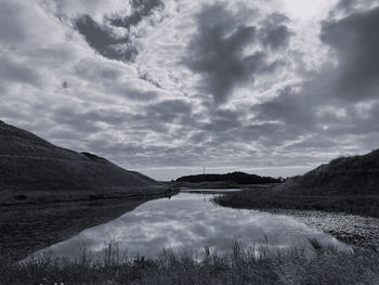 Scenic view of lake by mountain against sky