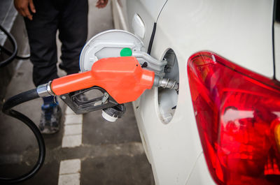 Low section of man refueling car