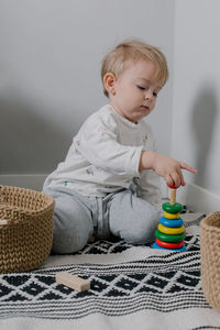 Portrait of cute baby boy sitting on sofa at home