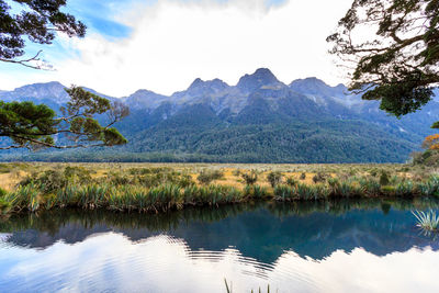 Scenic view of lake by mountains against sky