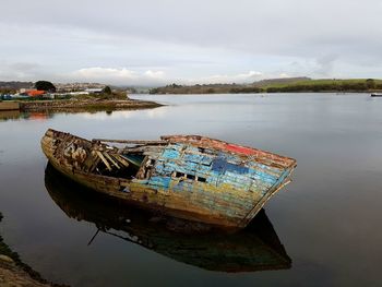 Boat moored on shore against sky