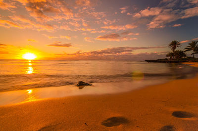 Scenic view of beach against sky during sunset