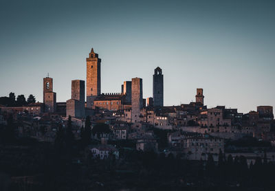 Buildings in city against clear sky