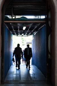 Rear view of silhouette people walking in corridor