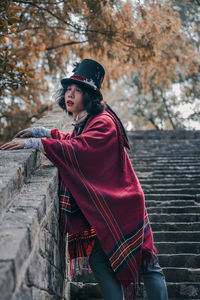 Side view of man cosplaying mad hatter looking away outdoors on the side of stairs