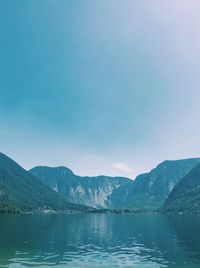 Scenic view of lake and mountains against blue sky