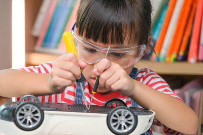 Close-up of boy playing with toy car