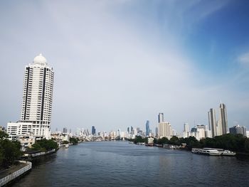 River by buildings against sky in city