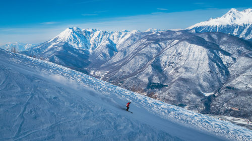 High angle view of man skiing on snowcapped mountains against sky