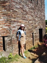 Full length of man standing against building wall