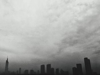 Low angle view of buildings against cloudy sky