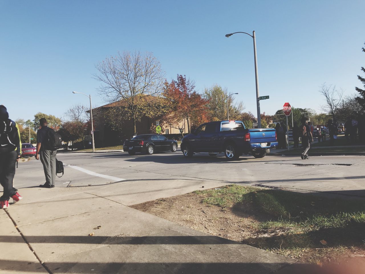 car, tree, land vehicle, street, transportation, sunlight, road, shadow, real people, outdoors, day, clear sky, sky, city, one person, people