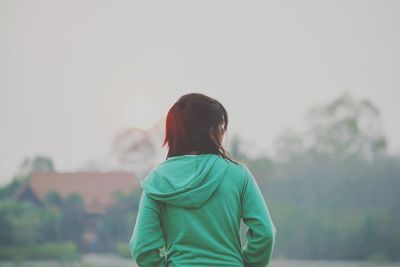 Rear view of woman standing against sky