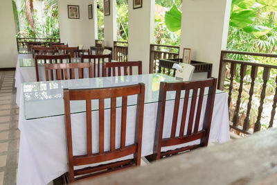 Empty chairs and tables in balcony against building