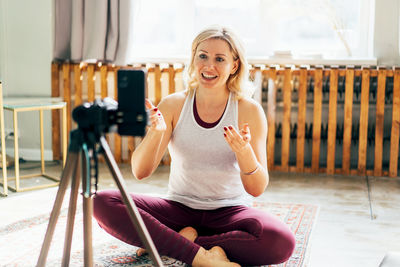 Smiling woman vlogging at home