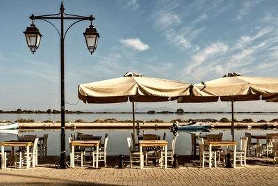 Low angle view of street lights on beach against sky