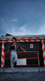 Full length portrait of woman standing against sky