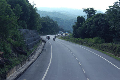 Road amidst trees against sky