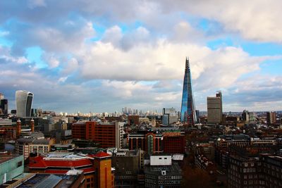 View of cityscape against cloudy sky