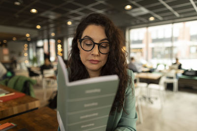 Businesswoman checking diary in cafe