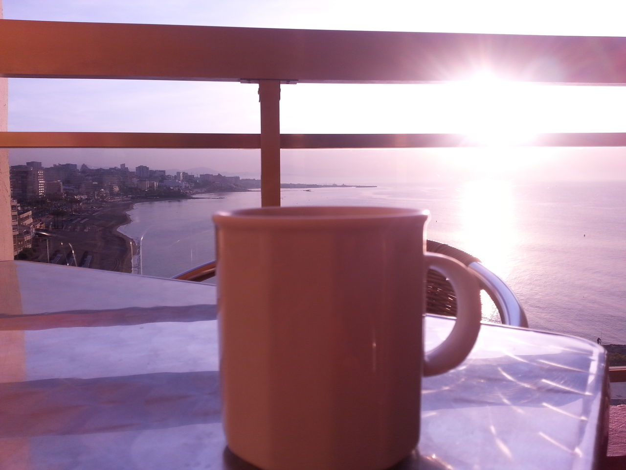 drink, food and drink, table, refreshment, freshness, coffee cup, still life, sunlight, coffee - drink, sunset, close-up, sky, water, drinking glass, sea, chair, no people, saucer, orange color, outdoors